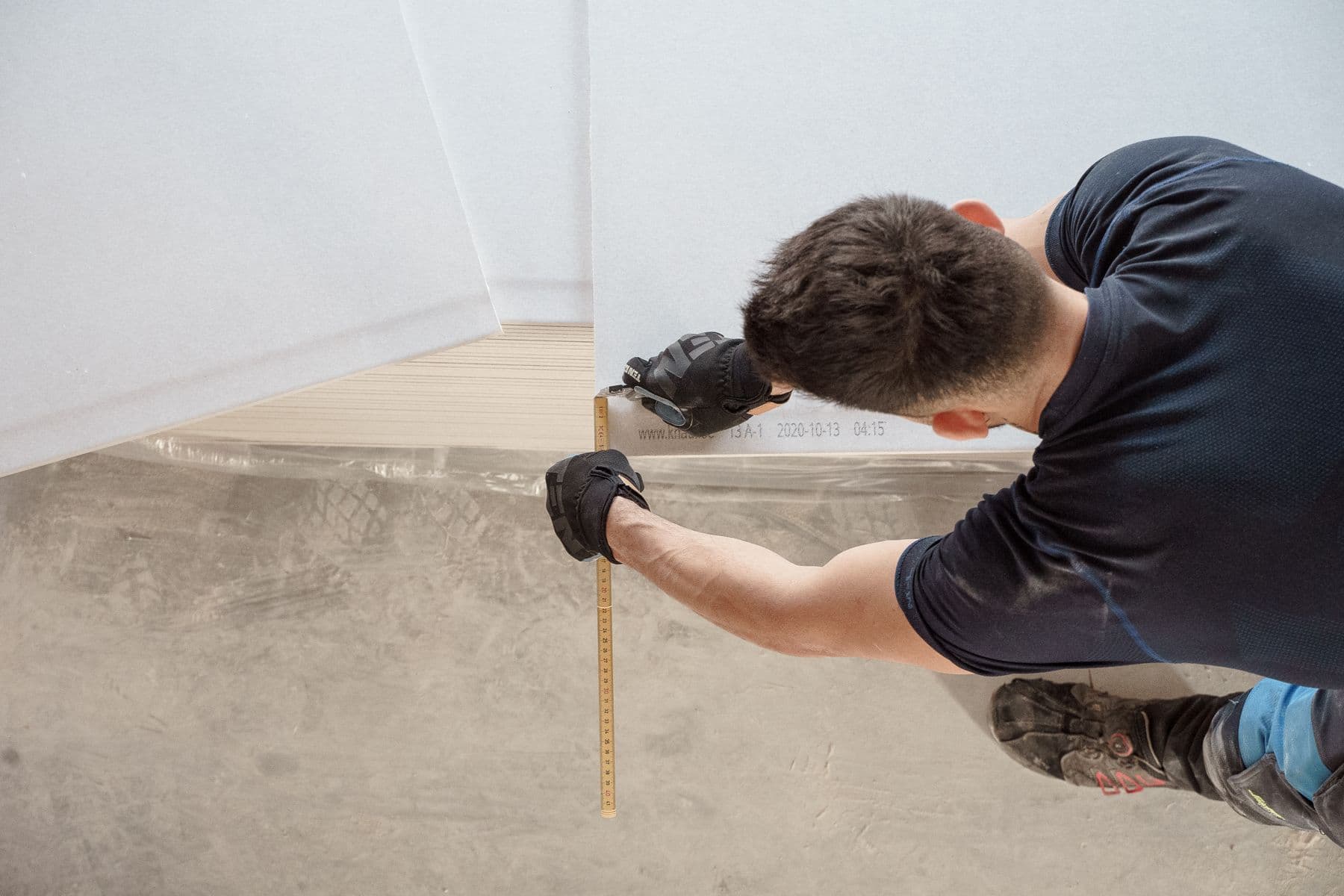 Close view of a worker measuring a panel during an interior renovation